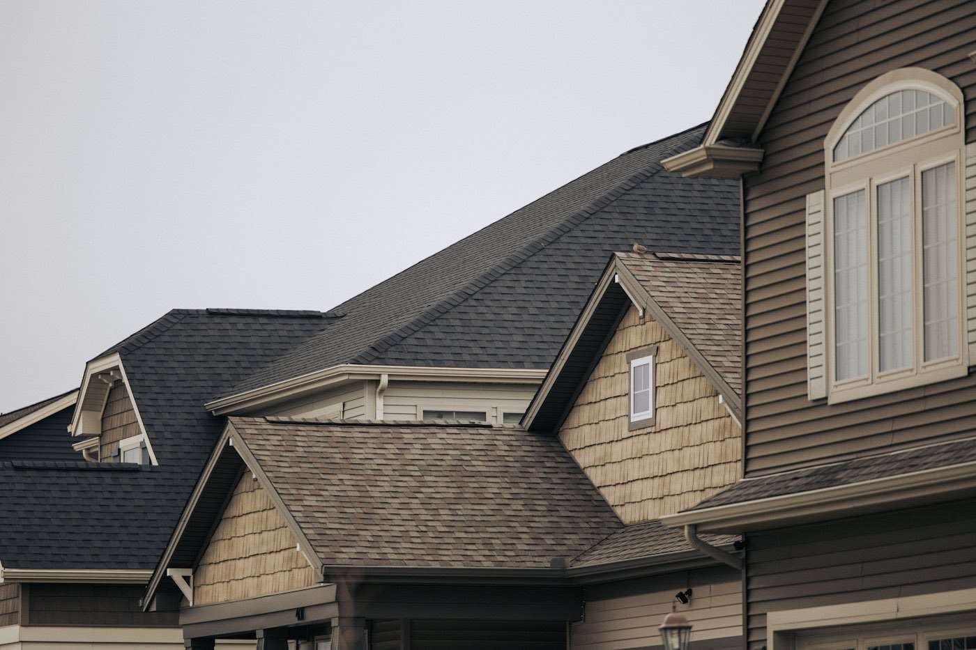 Row of houses with brown architectural shingles and white trim